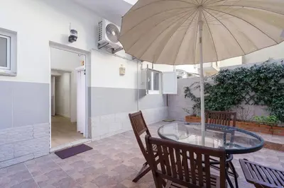 a glass table with an umbrella on a patio at APOSENTUS - Serenity Terrace in Porto
