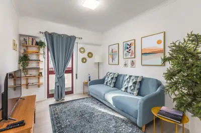 a living room with a blue couch and a tv at Hopstays - Oporto Musica in Porto