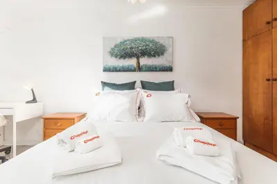 a bedroom with a white bed with two towels on it at Hopstays - Oporto Musica in Porto
