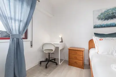 a bedroom with a bed and a desk and a window at Hopstays - Oporto Musica in Porto