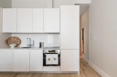 a kitchen with white cabinets and a stove at GuestReady - Bonjardim Building in Porto