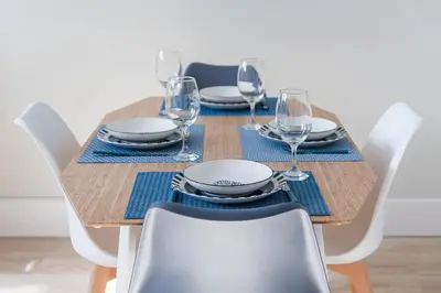 a dining room table with chairs and a wooden table with wine glasses at GuestReady - Bonjardim Building in Porto