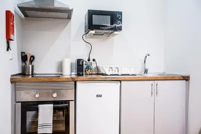 a kitchen with a counter with a tv on the wall at Emotions Lapa Flat in Porto