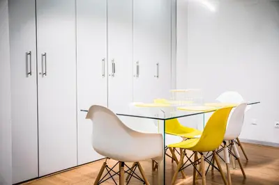 a dining room with a glass table and yellow chairs at Emotions Lapa Flat in Porto