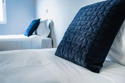 a black pillow sitting on top of a bed at Emotions Lapa Flat in Porto