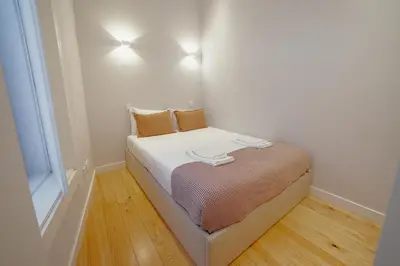 a small bed in a room with a window at Downtown Amazing Duplex by Vacationy in Porto