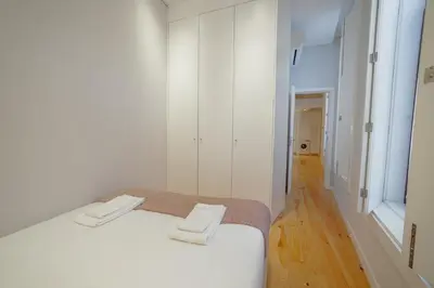 a white bedroom with a bed and a mirror at Downtown Amazing Duplex by Vacationy in Porto