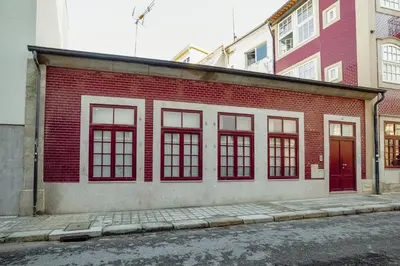 a red brick building with windows on a street at Downtown Amazing Duplex by Vacationy in Porto