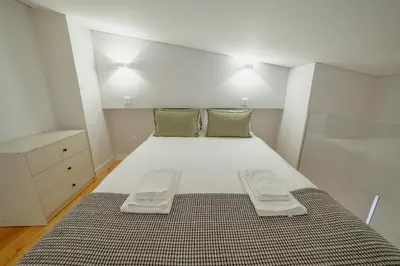 a bedroom with a large white bed with two pillows at Downtown Amazing Duplex by Vacationy in Porto