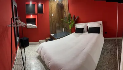a bedroom with a white bed with a red wall at Modern & Central 3 minutes from the River in Vila Nova de Gaia