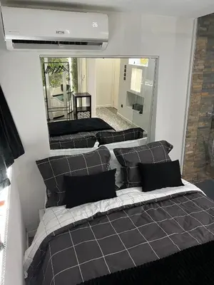 a room with a bed with pillows and a mirror at Modern Room with Indoor Shower Near the River - Quarto Moderno com Duche interior Próximo da Ribeira in Vila Nova de Gaia