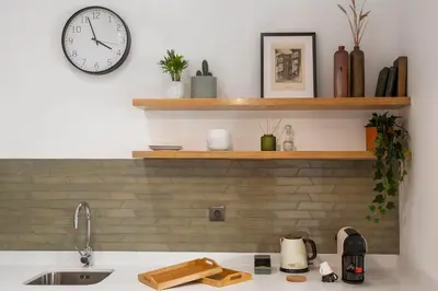 a kitchen with a sink and a clock on the wall at WALAA Home@Almada Terrace by LovelyStay in Porto