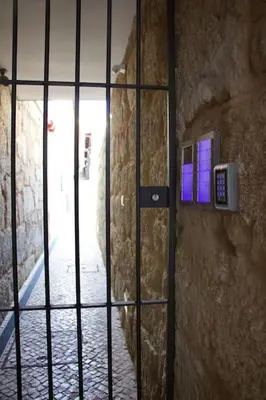 a door with a iron gate in a stone wall at Ilhas Douro Fontaínhas by PA Hotels in Porto