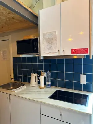 a kitchen with white cabinets and blue tiles at Ilhas Douro - Fontaínhas by PA Hotels in Porto