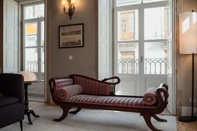 a living room with a couch in front of a window at Estefânia Luxury Apartment Historic House Downtown in Porto
