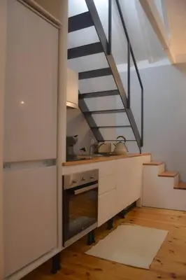 a kitchen with a sink and a staircase at The Nest in Porto