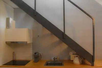 a kitchen with a sink and a metal staircase at The Nest in Porto