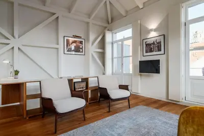 a living room with two chairs and a desk and a tv at Victoria Luxury Apartment, Historic House Downtown in Porto