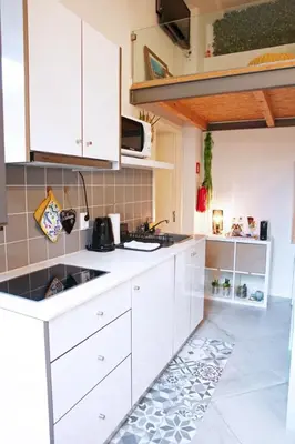 a kitchen with white cabinets and a counter top at Ilha D’ouro House S. Vitor in Porto
