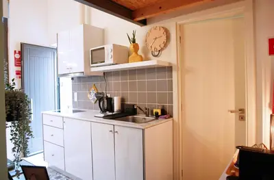 a kitchen with a sink and a clock on the wall at Ilha D’ouro House S. Vitor in Porto