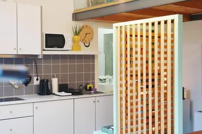 a kitchen with white cabinets and a partition with at Ilha D’ouro House S. Vitor in Porto