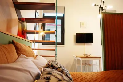 a bedroom with a bed and a desk with a television at Ilha D’ouro House S. Vitor in Porto