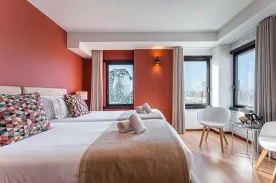 a bedroom with two beds with red walls and windows at GuestReady - Portfolio GuestHouse in Porto