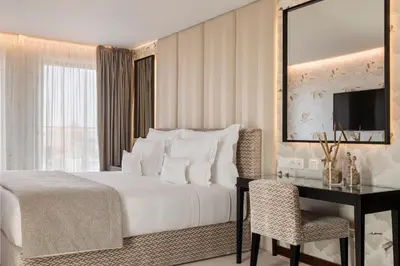 a bedroom with a bed and a desk and a television at Wine & Books Porto Hotel - Small Luxury Hotels Of The World in Porto