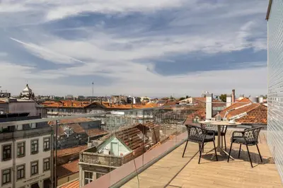 a balcony with two chairs and a table on a building at Wine & Books Porto Hotel - Small Luxury Hotels Of The World in Porto