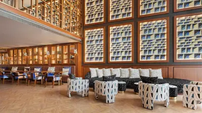 a restaurant with a couch and tables and windows at Wine & Books Porto Hotel - Small Luxury Hotels Of The World in Porto