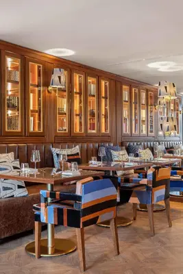a restaurant with wooden tables and blue chairs at Wine & Books Porto Hotel - Small Luxury Hotels Of The World in Porto
