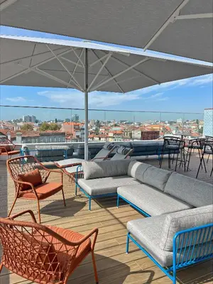 a patio with a couch and chairs and an umbrella at Wine & Books Porto Hotel - Small Luxury Hotels Of The World in Porto