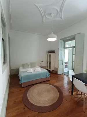 a bedroom with a bed and a table and a rug at Porto InLapa Apartment II Terrace in Porto