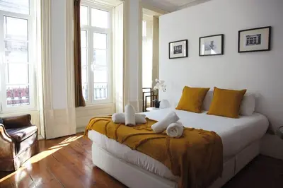 a bedroom with a large bed with yellow pillows at InLapa Studio III in Porto