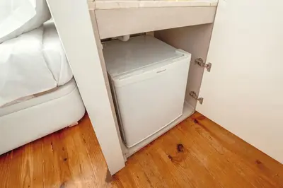 a small white refrigerator in a corner of a room at InLapa Studio III in Porto