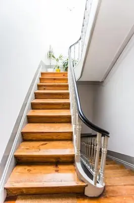 a staircase with wooden floors and a metal railing at InLapa Studio III in Porto