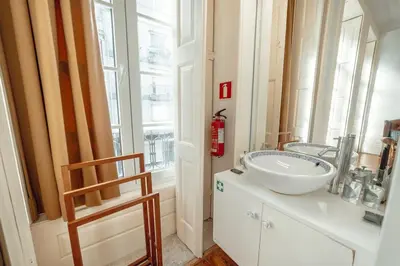 a bathroom with a white sink and a window at InLapa Studio III in Porto