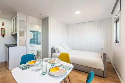 a small room with a bed and a table and chairs at Terrace Douro in Vila Nova de Gaia
