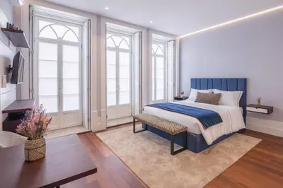 a bedroom with a bed and a tv and windows at Porto Almada 180 Apartments in Porto