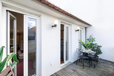 a patio with a table and chairs on a balcony at Bonfim Elegant Duplex w/ AC by LovelyStay in Porto