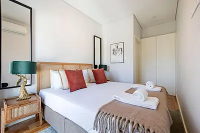a bedroom with a large white bed with towels on it at Bonfim Elegant Duplex w/ AC by LovelyStay in Porto