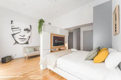a white bedroom with a large white bed with yellow pillows at GuestReady - Studio Five-0-Five in Porto
