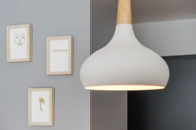 a white light hanging from a ceiling with framed pictures at GuestReady - Studio Five-0-Five in Porto