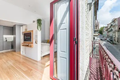 a balcony with a red door and a bedroom at GuestReady - Studio Five-0-Five in Porto