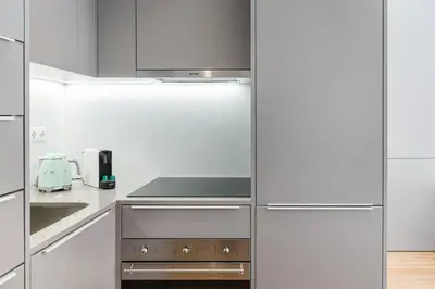 a kitchen with stainless steel appliances and white cabinets at GuestReady - Studio Five-0-Five in Porto