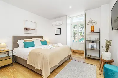 a bedroom with a large bed with blue pillows at Monte dos Judeus I by Innkeeper in Porto