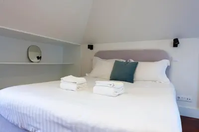 a bedroom with a white bed with towels on it at Trindade - Loft apartment in Porto