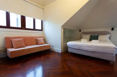 a bedroom with a bed and a couch at Trindade - Loft apartment in Porto