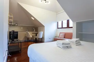 a bedroom with a bed and a living room at Trindade - Loft apartment in Porto