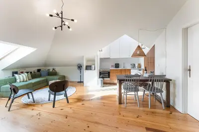 a kitchen and living room with a table and chairs at GuestReady - Spacious and modern Apt W/ Skylight in Porto